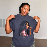 Person wearing a grey t-shirt with a graphic of a woman and text.